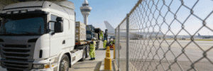 A heavy transport truck being loaded with commercial cargo outside Dubai Airport to ensure continuous supply chain operations.