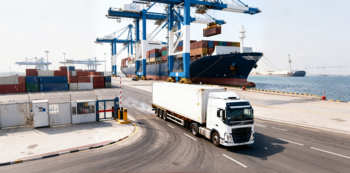 A Three Lines Shipping heavy container truck stands ready at Hamad Port in Qatar, illustrating efficient multimodal sea and road transport links.